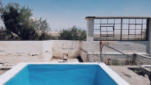 abandoned blue pool with chair in front in zzyzx, california