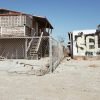 abandoned buildings in saltonsea with graffiti that says "sell"