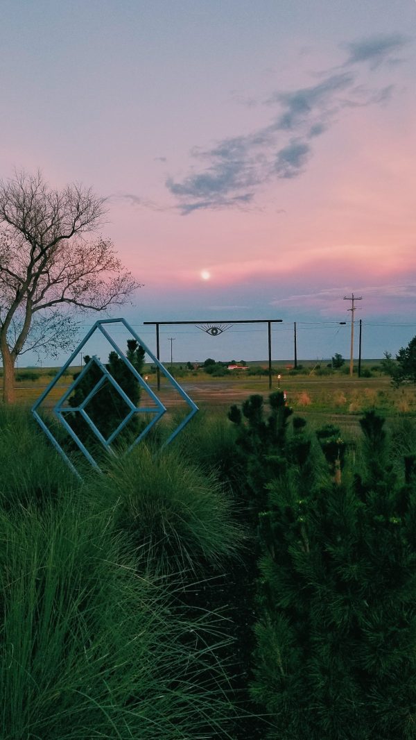 pink sunset with blue sculpture and eye