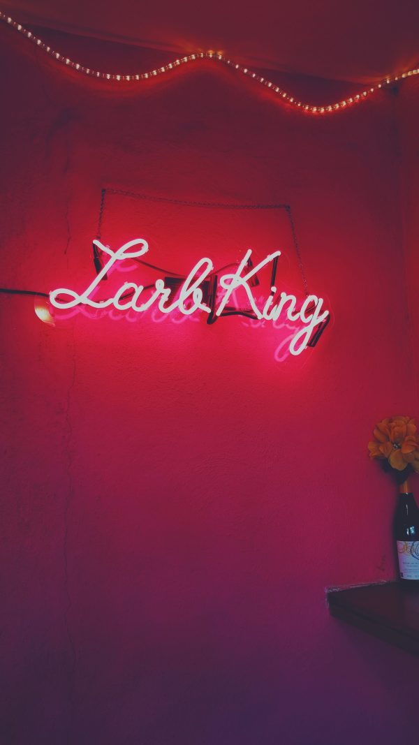 pink neon sign on pink wall that says "larb king"