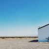 white church in the desert with a fallen cross over the door