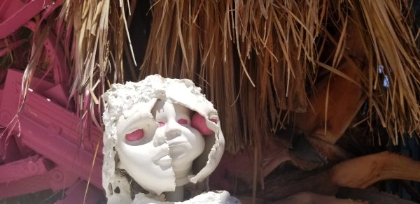 white broken doll head with pink eyes with more broken white doll heads inside