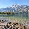 photo of clear water with pebbles at the bottom and mountain in background