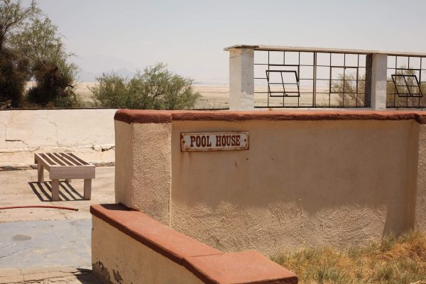 photo of abandoned pool house with "pool house" sign