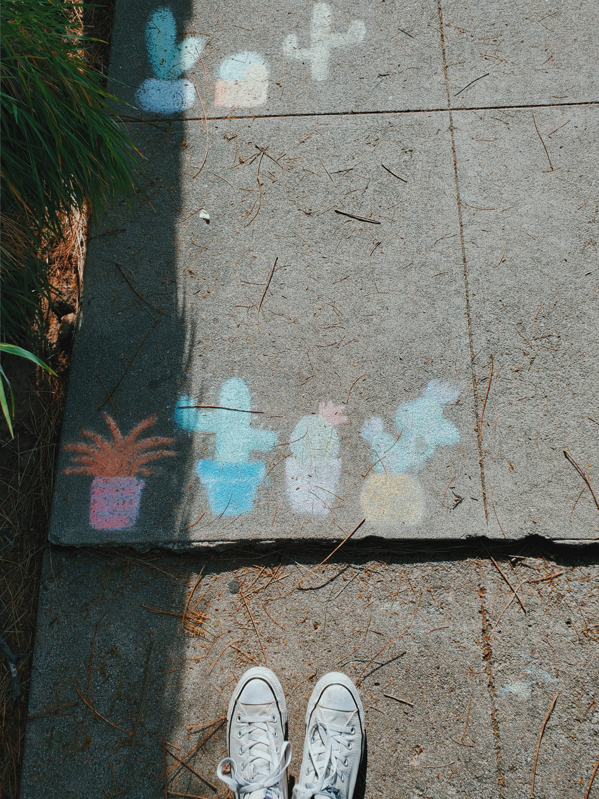 photo of white shoes on sidewalk with chalk art