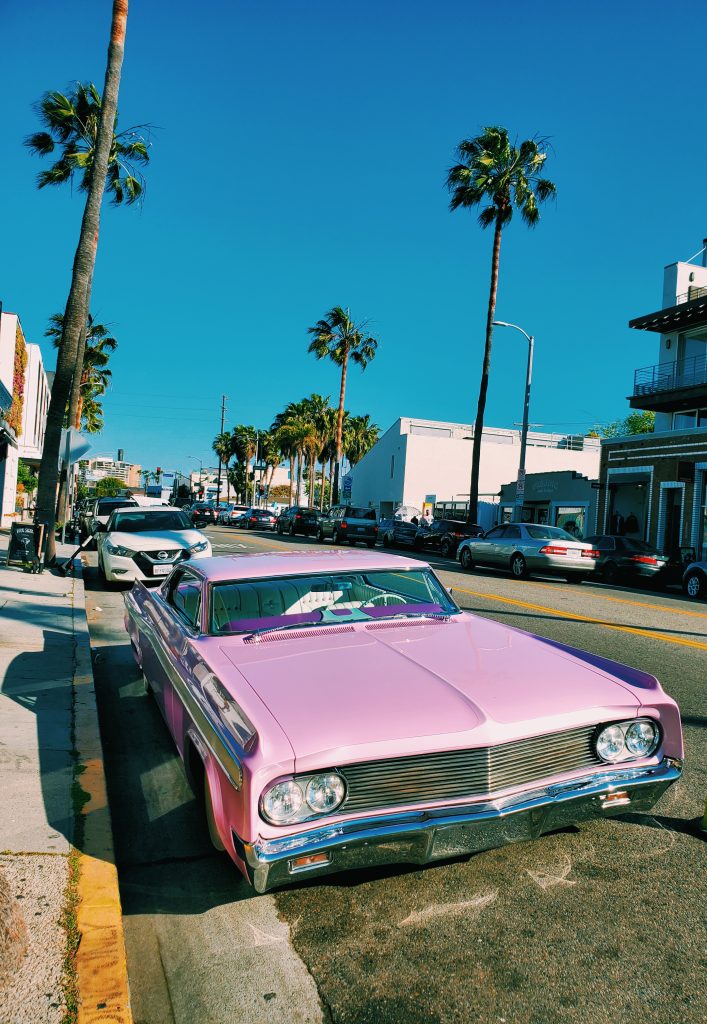 pink cadillac parked on the streets of los angeles